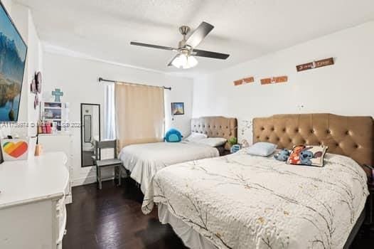 bedroom featuring a ceiling fan and dark wood finished floors