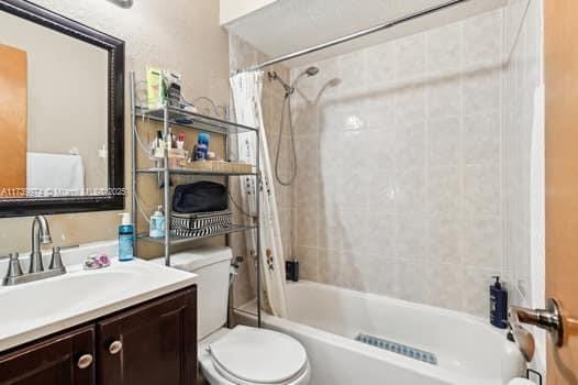 bathroom featuring shower / bath combination with curtain, vanity, and toilet