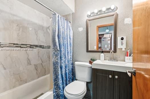 full bath featuring toilet, shower / tub combo with curtain, and vanity