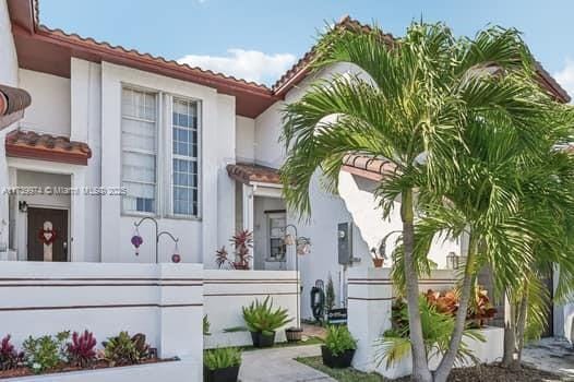 view of front of property featuring a tiled roof and stucco siding