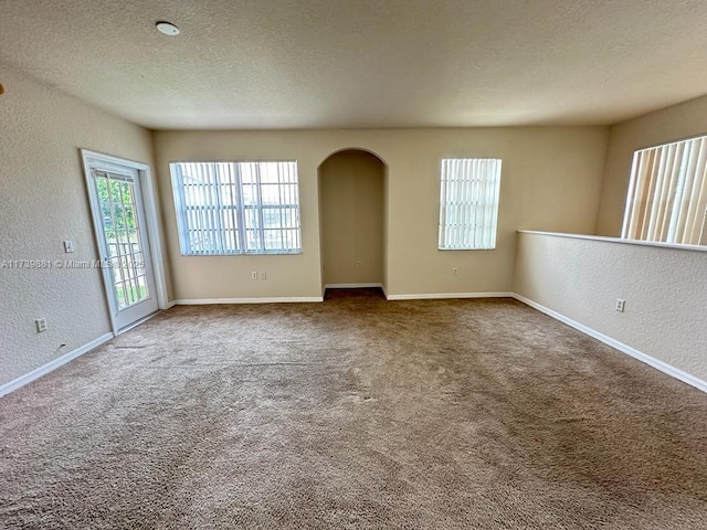 empty room featuring carpet floors and a textured ceiling