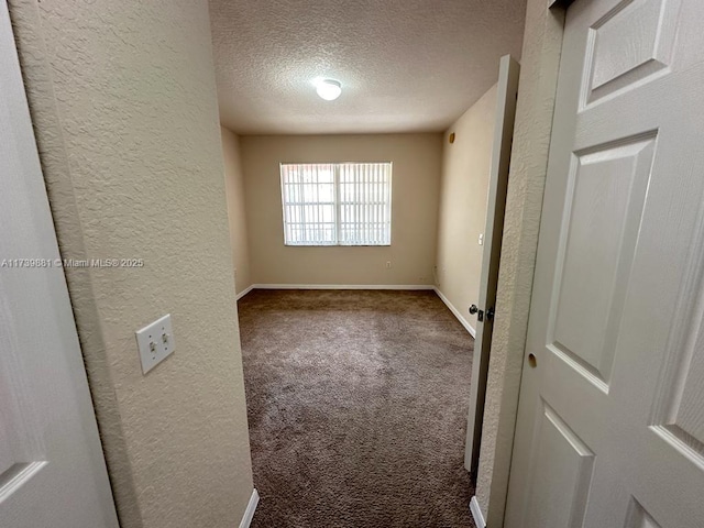 carpeted empty room with a textured ceiling