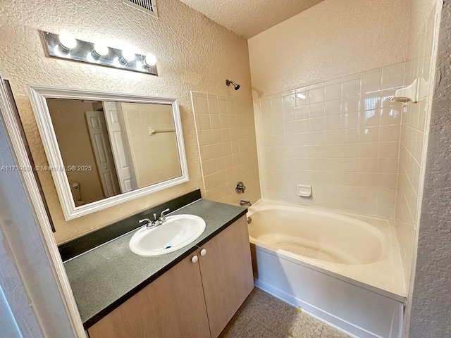 full bathroom featuring tile patterned flooring, vanity, a textured ceiling, shower / washtub combination, and toilet