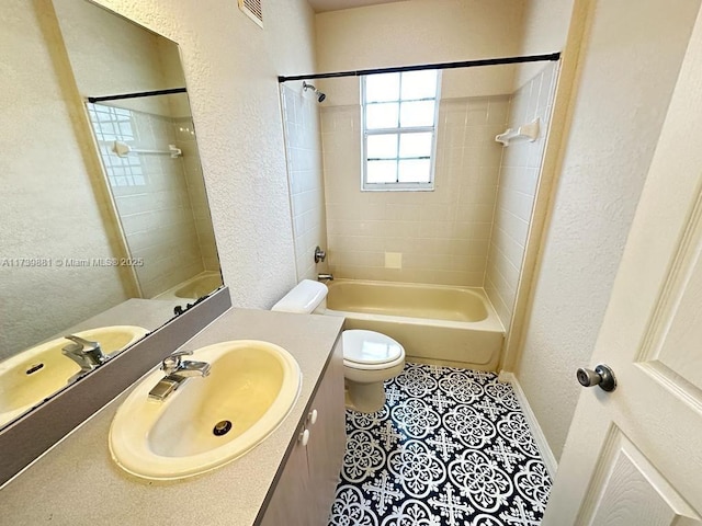 full bathroom featuring vanity, tiled shower / bath, tile patterned floors, and toilet