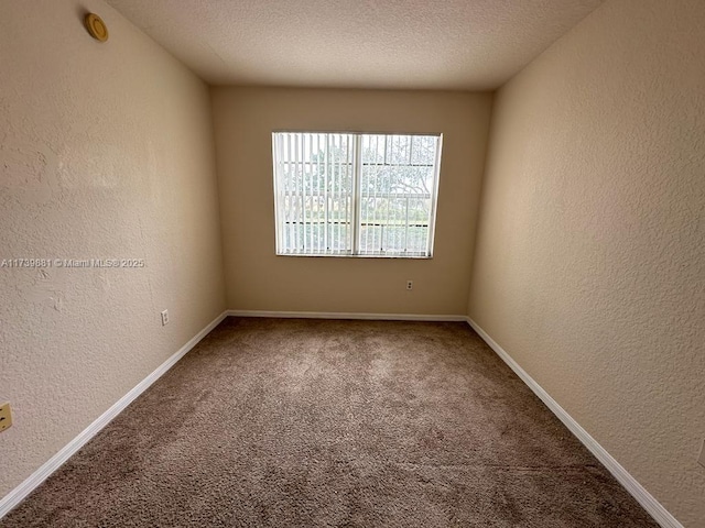 carpeted spare room with a textured ceiling