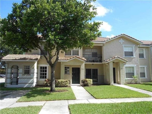 mediterranean / spanish house with a front lawn