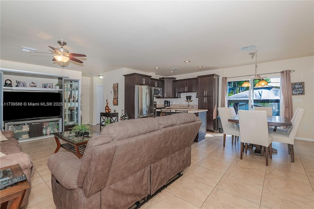 living room featuring light tile patterned floors and ceiling fan