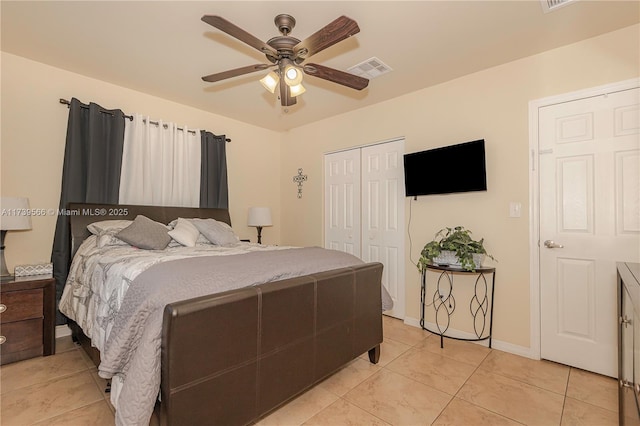 bedroom featuring ceiling fan, a closet, and light tile patterned floors