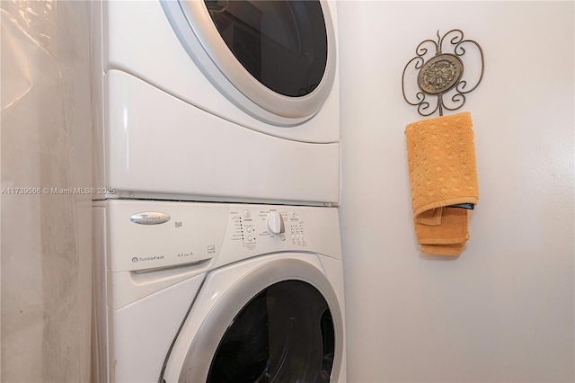 washroom with stacked washing maching and dryer