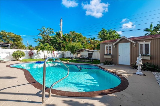 view of swimming pool with an outbuilding and a patio