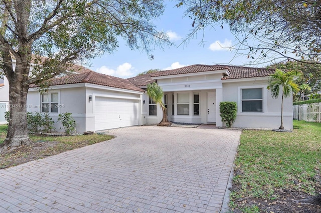 mediterranean / spanish home featuring a garage and a front lawn