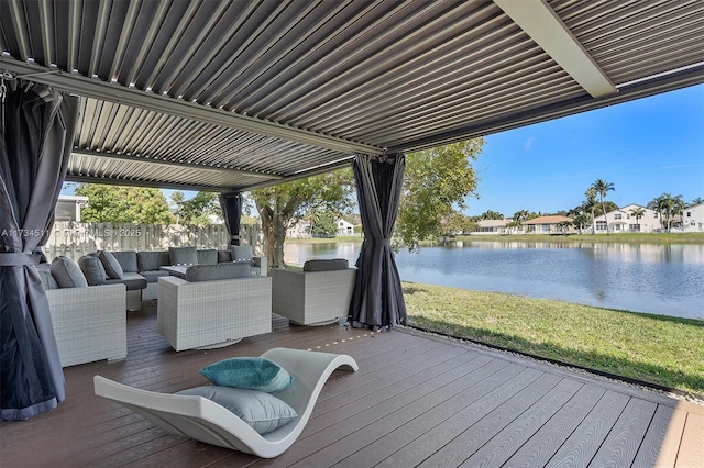 wooden terrace featuring a water view, an outdoor hangout area, and a lawn