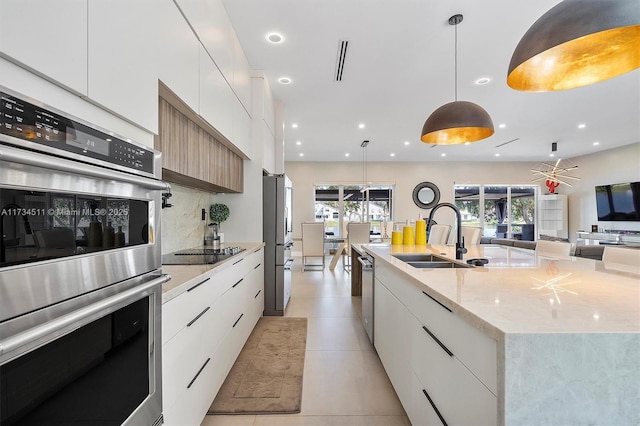 kitchen featuring hanging light fixtures, white cabinetry, appliances with stainless steel finishes, and a large island