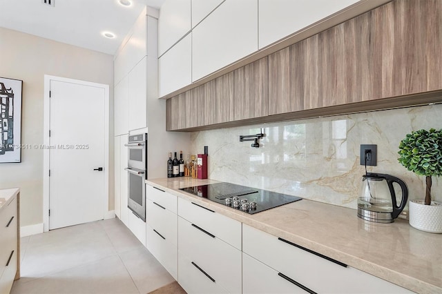 kitchen with black electric cooktop, light tile patterned floors, double oven, and white cabinets