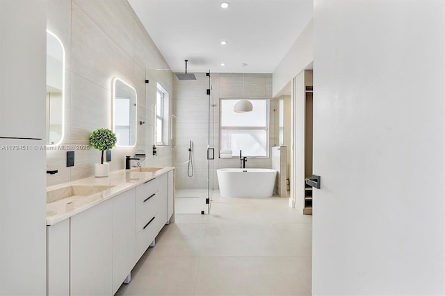 bathroom featuring tile walls, vanity, tile patterned floors, and shower with separate bathtub