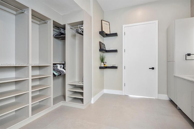 walk in closet with light tile patterned floors