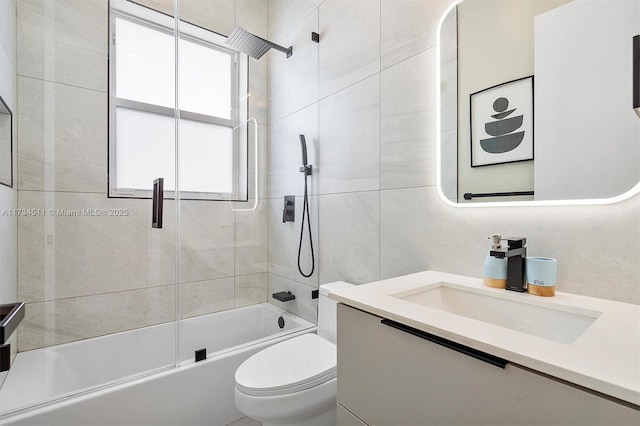 full bathroom featuring vanity, combined bath / shower with glass door, a wealth of natural light, and toilet