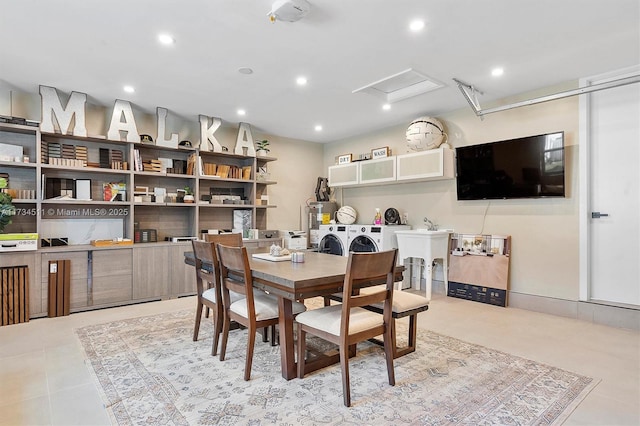 tiled dining room with independent washer and dryer and sink