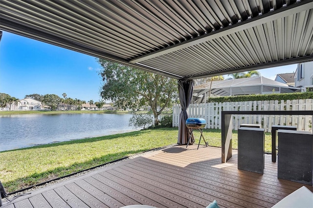 deck with a water view, area for grilling, and a lawn