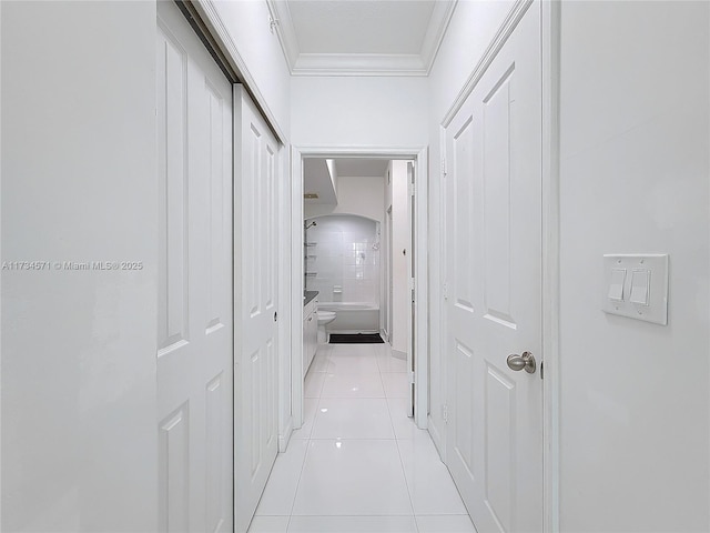 hall with ornamental molding and light tile patterned floors