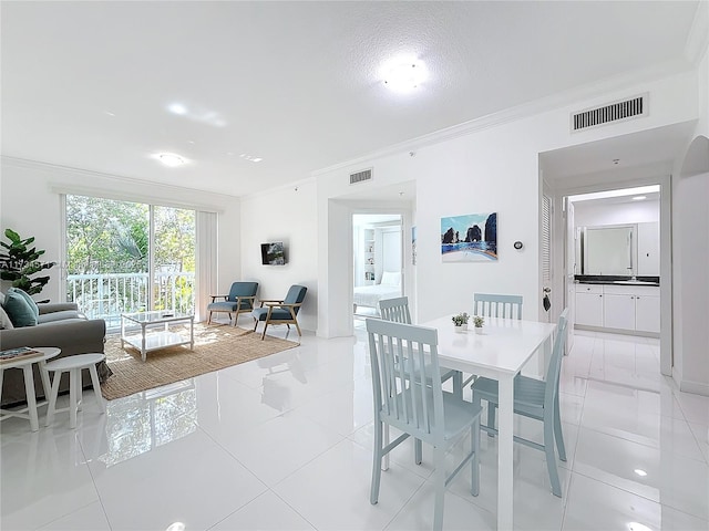 dining space featuring light tile patterned floors and crown molding