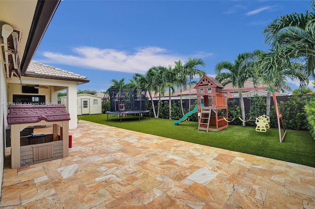 view of patio with a storage unit, a playground, and a trampoline