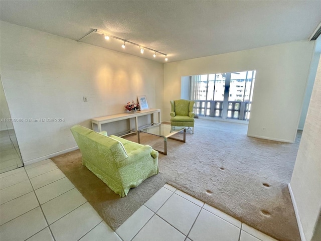 living room with rail lighting, light colored carpet, and a textured ceiling