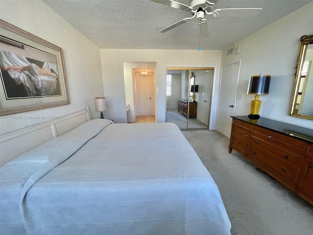 bedroom featuring ceiling fan, light carpet, and a textured ceiling