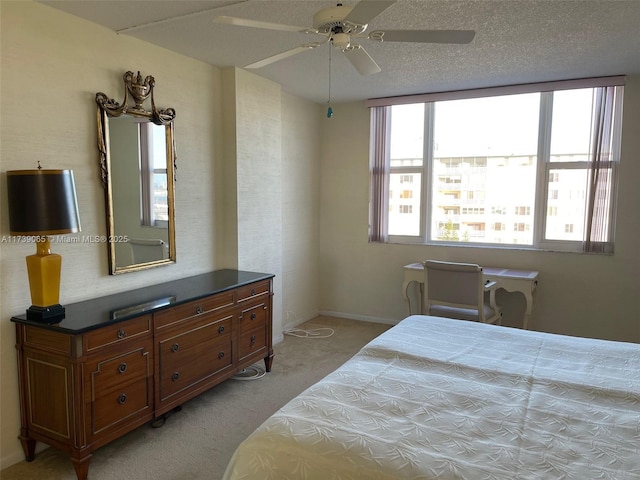 carpeted bedroom with ceiling fan and a textured ceiling