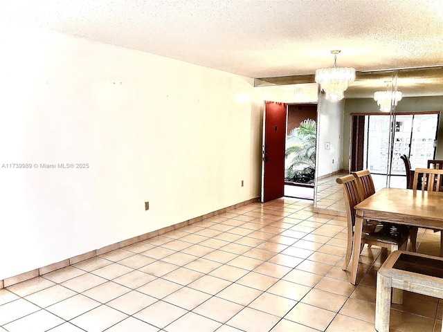 dining room with light tile patterned floors, baseboards, a notable chandelier, and a textured ceiling