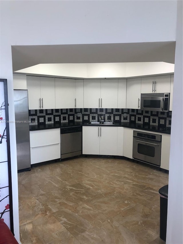 kitchen with backsplash, stainless steel appliances, sink, and white cabinets