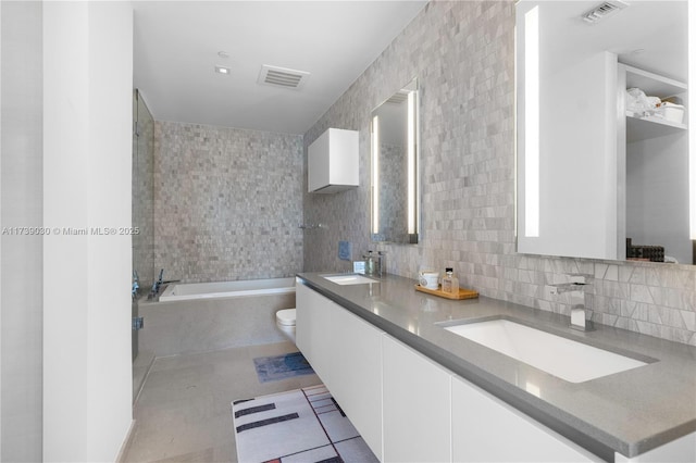 bathroom with toilet, tile walls, vanity, a bath, and backsplash