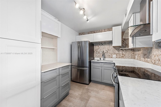 kitchen with sink, tasteful backsplash, ventilation hood, appliances with stainless steel finishes, and gray cabinets