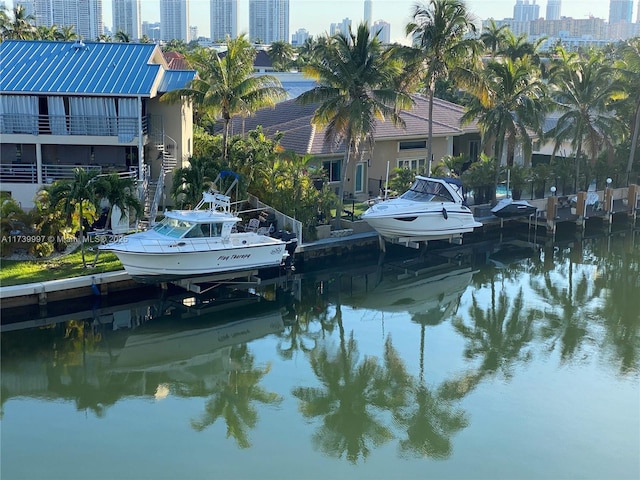 dock area featuring a water view, boat lift, and a view of city