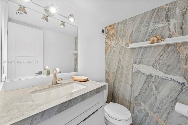 full bathroom featuring vanity, tiled shower / bath combo, and toilet