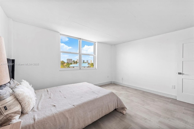 bedroom with baseboards and wood finished floors