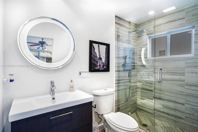 bathroom featuring vanity, an enclosed shower, ceiling fan, and toilet