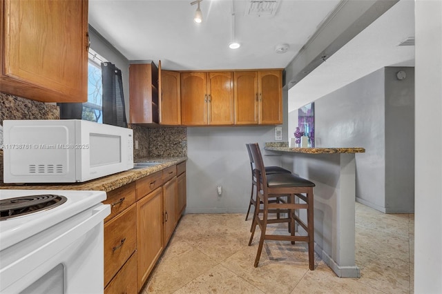 kitchen featuring backsplash and a breakfast bar area