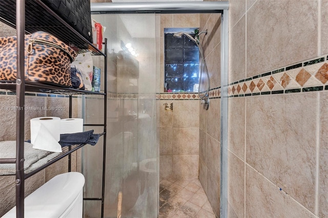 bathroom featuring tiled shower and toilet