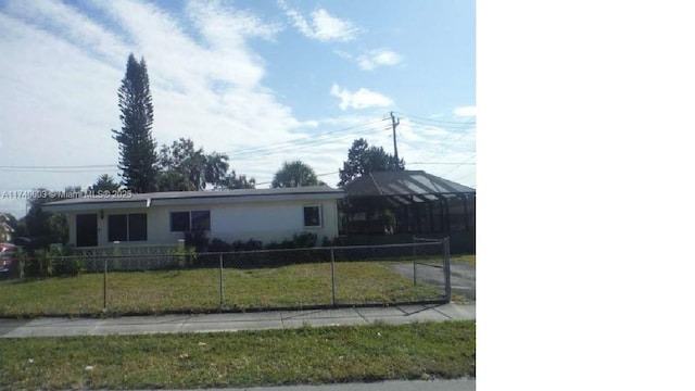 ranch-style house with fence and a front lawn