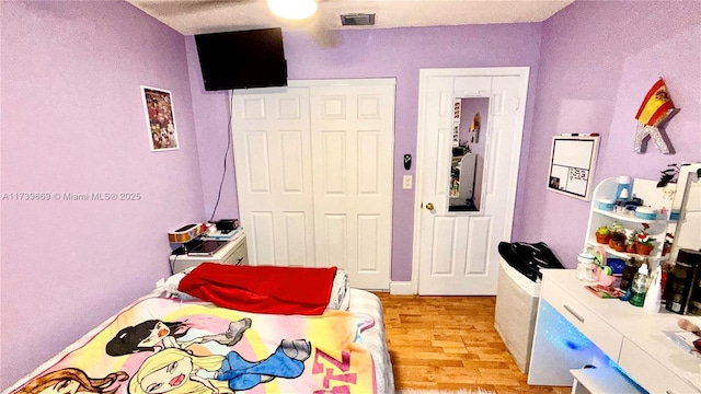 bedroom with light hardwood / wood-style flooring and a closet