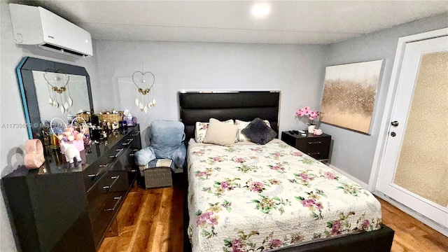 bedroom featuring dark hardwood / wood-style floors and a wall mounted AC