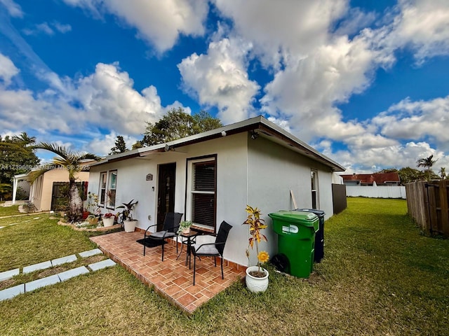 rear view of house with a yard and a patio