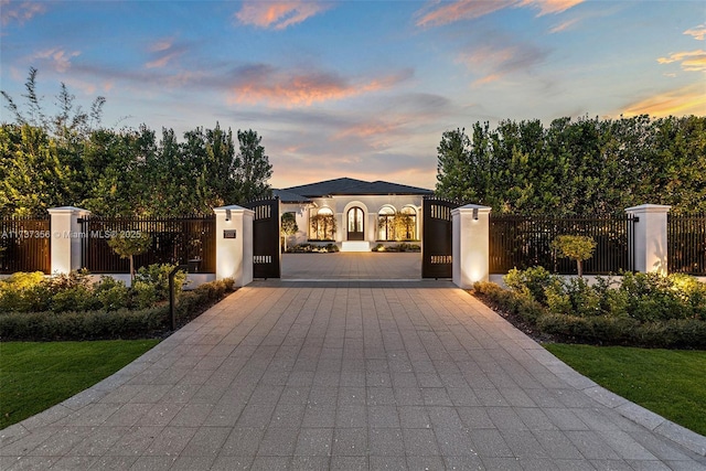 gate at dusk with a fenced front yard