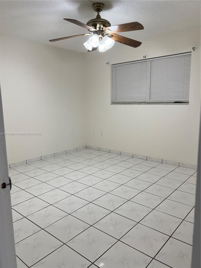 tiled spare room with ceiling fan and a textured ceiling