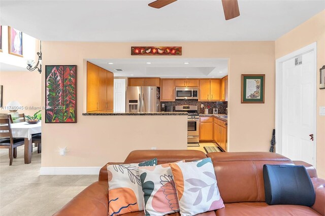 living room with a ceiling fan, stairway, visible vents, and baseboards