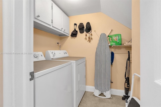 laundry area with light tile patterned floors, washer and clothes dryer, cabinet space, and baseboards