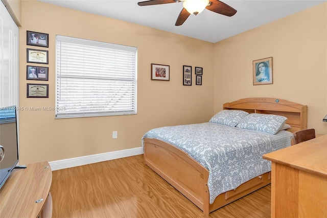 bedroom with wood finished floors, a ceiling fan, and baseboards