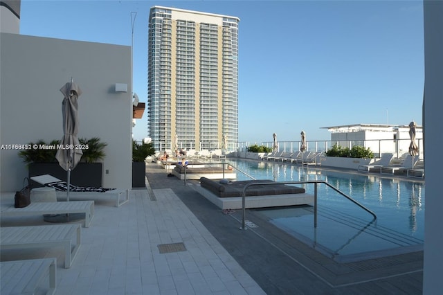 view of pool with a water view and a patio area