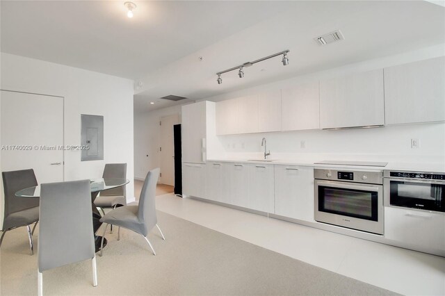 living room featuring sink, light colored carpet, and electric panel